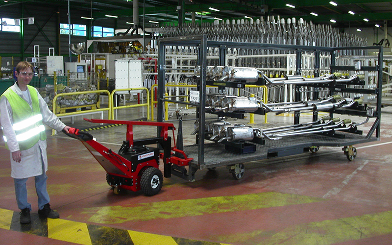 Power Pusher, with Steering Arm, moving trolley loaded with automotive exhaust assemblies at Faurecia, France