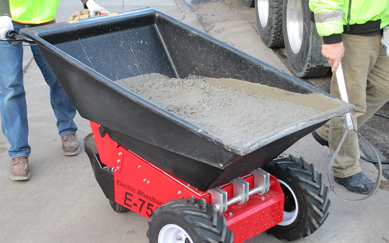 Electric Wheelbarrow loaded with concrete from concrete delivery lorry