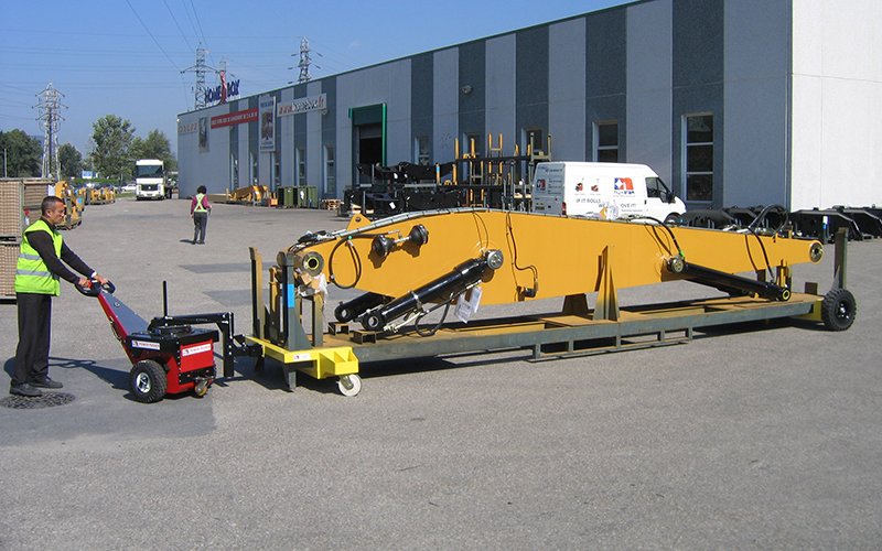 Power Pusher moving 3,500Kg excavator boom stillage on temporary steerable wheelsets for Caterpillar