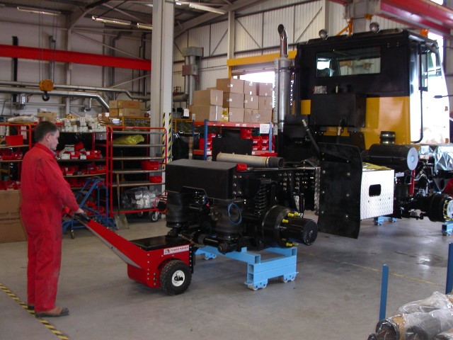 Power Pusher moving Off-Highway vehicle chassis on skates along production line